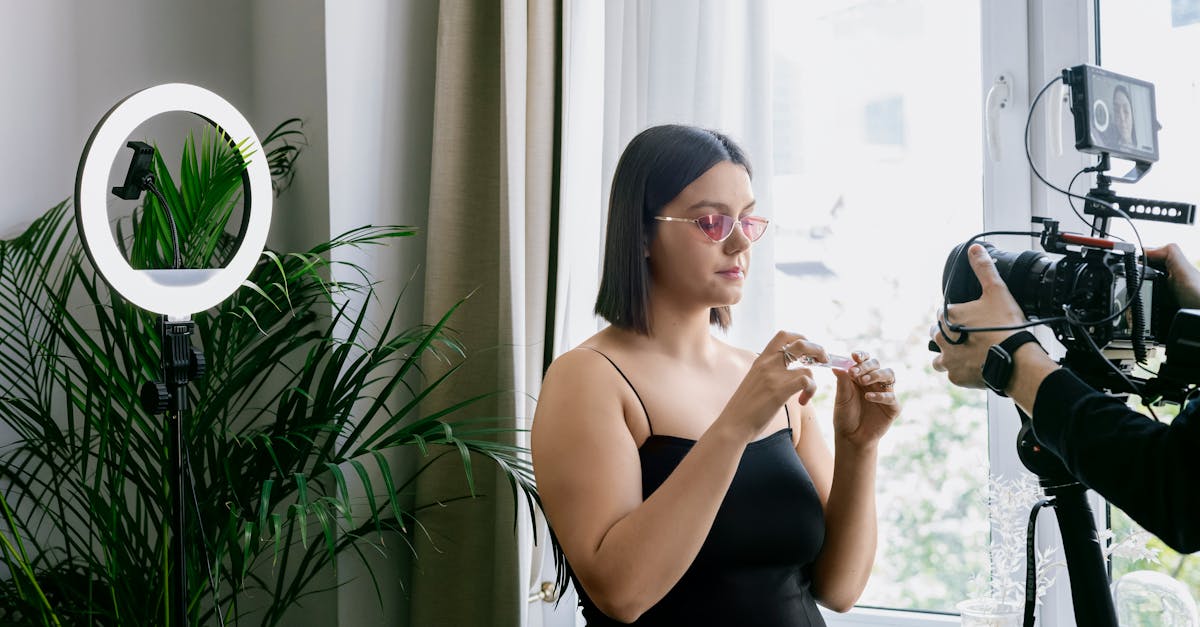 Woman filming a product review indoors with a camera and ring light.